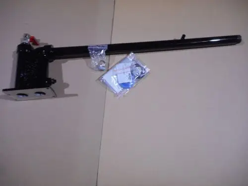 Schwarzes Anschlussstück von Remeha mit einem langen Arm und einem Ventil, liegend auf einem hellem Hintergrund.